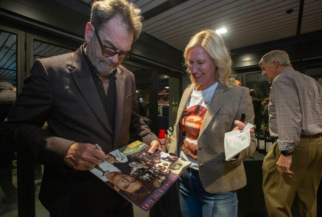 Singer and songwriter Huey Lewis signs an album cover for Jaime Powers Book shortly before his appearance as a guest of the Sonoma Speaker Series.  Huey Lewis, American singer, songwriter and founder of the group Huey Lewis & the News, appeared in conversation with former Bay Area newscaster Ken Wayne at the Hanna Center on Monday, Feb. 10, 2025.   (Robbi Pengelly / The Sonoma Index-Tribune)